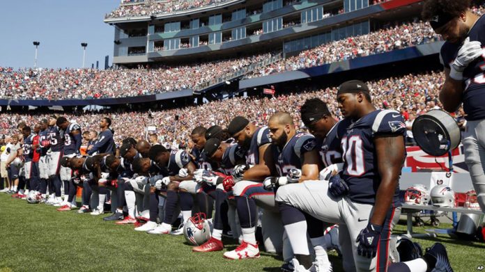 Page 4 Several New England Patriots players kneel during the national anthem before an NFL football game in protest against discrimination