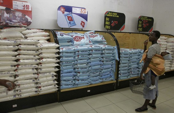 A Zimbabwean woman with a baby on her back looks on as she does some shopping at a leading supermarket in the capital Harare